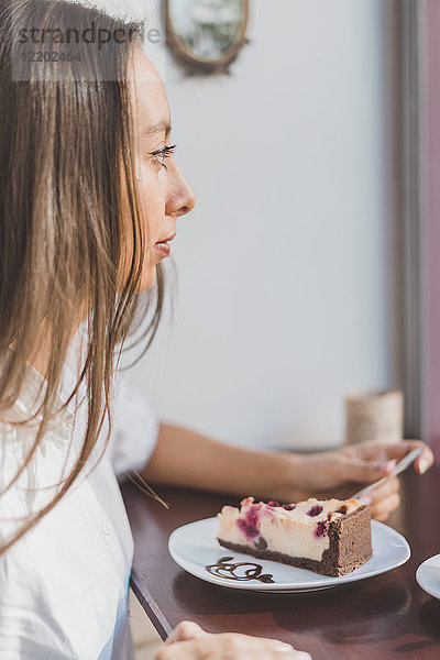 Frau isst Kuchen in einem Café