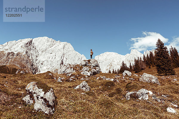 Österreich  Salzburger Land  Berchtesgadener Alpen  junge Frau auf Felsen stehend