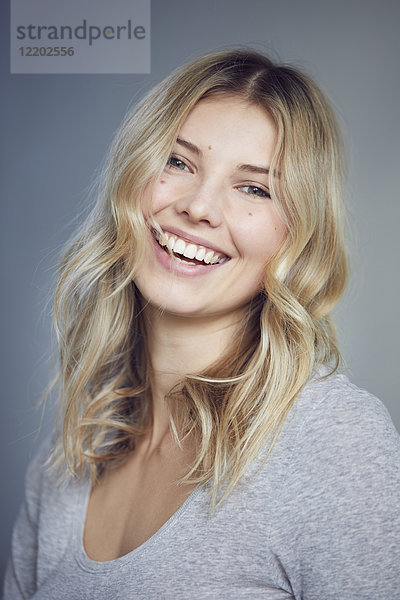 Porträt einer lachenden blonden Frau mit Maulwürfen