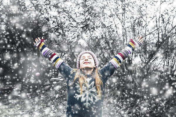 Glückliches Mädchen bei Schneefall