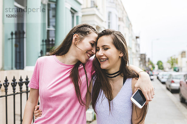 Zwei fröhliche Teenager-Mädchen unterwegs in der Stadt
