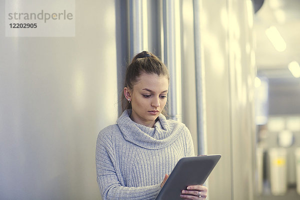 Porträt einer ernsthaften jungen Frau mit Tablette im Büro