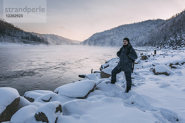 Russland  Oblast Amur  Mann am Flussufer von Bureya im Winter
