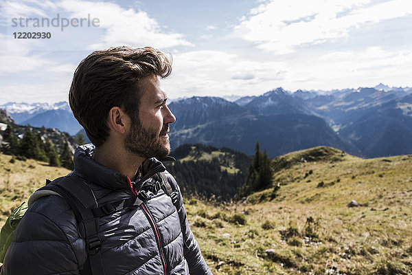 Österreich  Tirol  Porträt eines jungen Mannes in der Bergwelt mit Blick auf die Landschaft