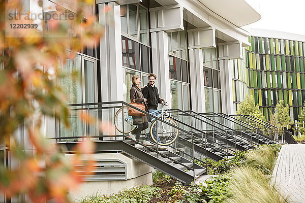 Lächelndes Paar verlässt das Haus mit Fahrrädern