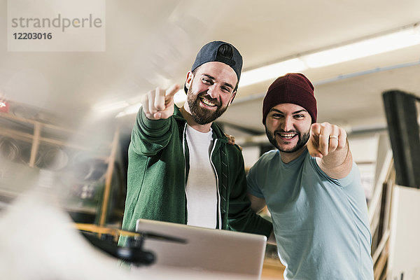 Porträt von zwei glücklichen jungen Männern in der Werkstatt