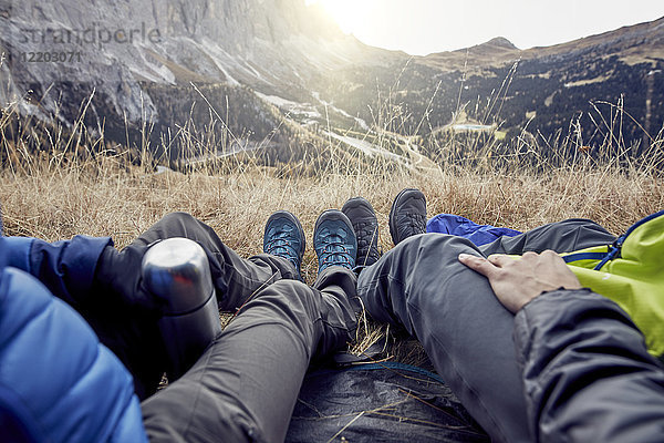 Beine eines Paares im Zelt in den Bergen sitzend