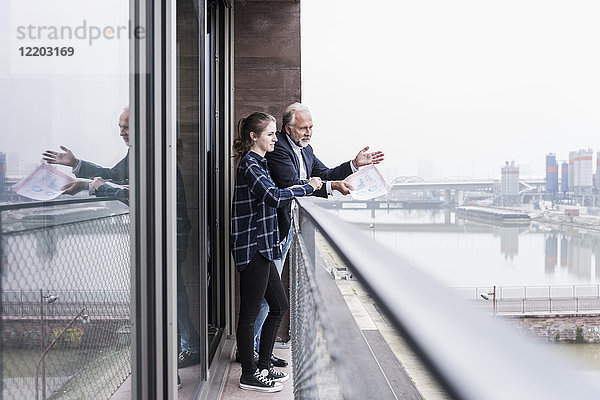 Geschäftsmann und junge Frau im Gespräch auf dem Balkon