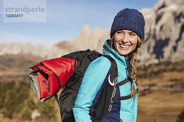 Porträt einer glücklichen jungen Frau beim Wandern in den Bergen