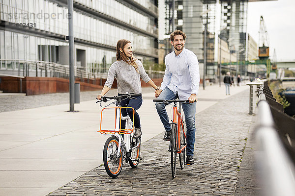 Lächelndes Paar beim Fahrradfahren in der Stadt
