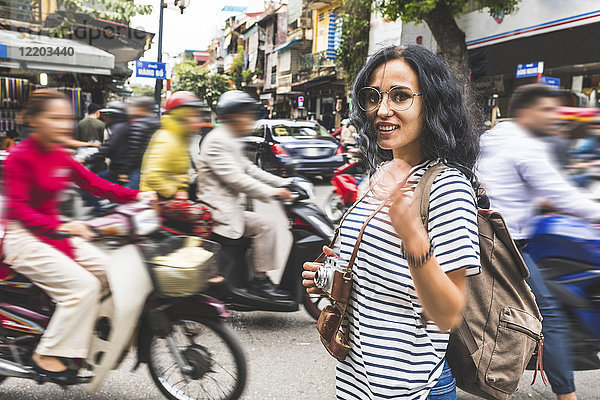 Vietnam  Hanoi  Porträt einer lächelnden jungen Frau im Stadtverkehr