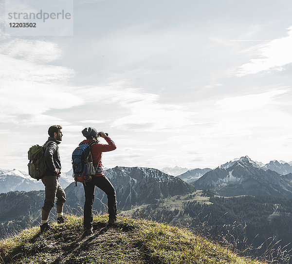 Österreich  Tirol  junges Paar in der Bergwelt stehend mit Blick auf die Landschaft