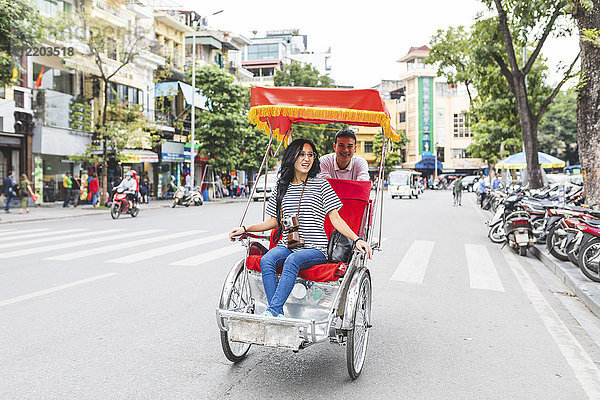 Vietnam  Hanoi  junge Frau auf einer Rikscha durch die Stadt