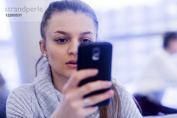 Portrait einer jungen Frau mit Smartphone
