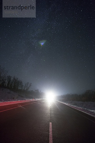 Russland  Oblast Amur  leere Landstraße unter Sternenhimmel im Winter