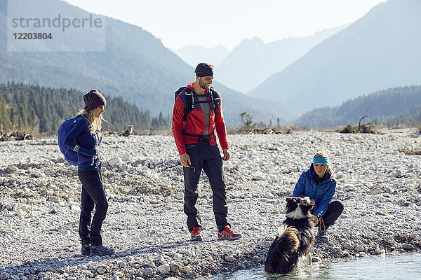 Deutschland  Bayern  Karwendel  Freundeskreis Wandern mit Hund am Flussufer