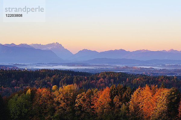 Deutschland  Bayern  Oberbayern  Alpenvorland  Kirchturm von Königsdorf  Zugspitze und Ammergauer Alpen bei Sonnenaufgang  Blick von der Peretshofener Höhe im Herbst