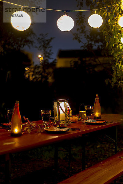 Gedeckter Tisch im Garten bei Nacht