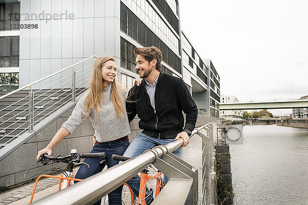 Lächelndes Paar mit Fahrrädern in der Stadt