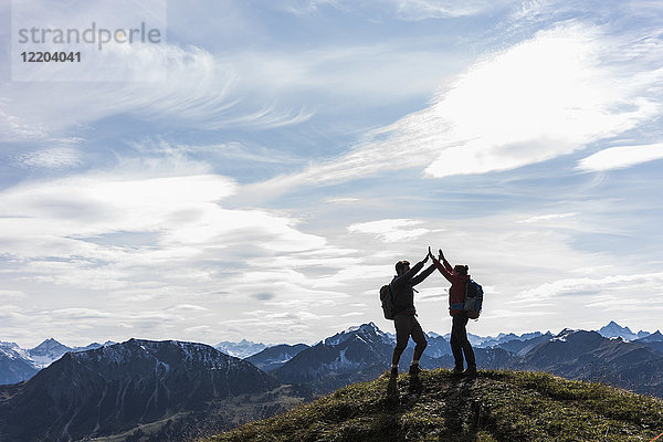 Österreich  Tirol  junges Paar  das in der Berglandschaft steht und jubelt