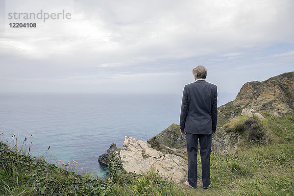 UK  Cornwall  Gwithian  Geschäftsmann an der Küste stehend mit Blick auf die Küste