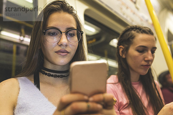 Teenager Mädchen mit Handy in der U-Bahn
