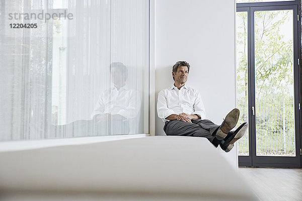 Geschäftsmann entspannt auf der Bank im modernen Büro