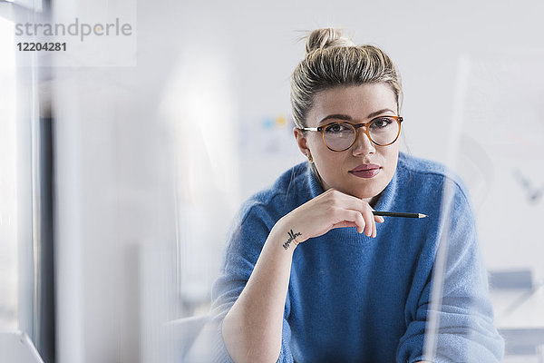 Porträt einer jungen Frau mit Brille im Büro