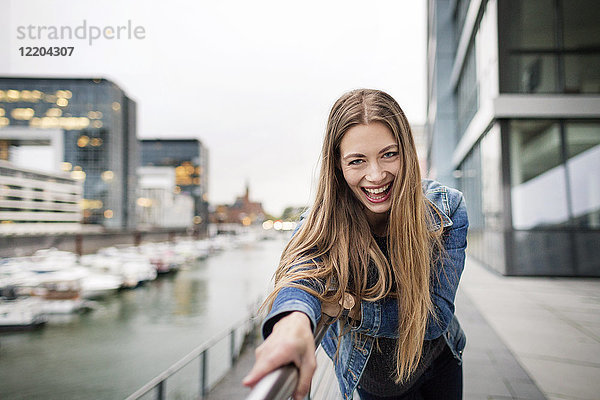 Porträt einer lachenden jungen Frau am Stadthafen