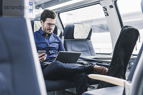 Geschäftsmann bei der Arbeit im Zug mit Laptop