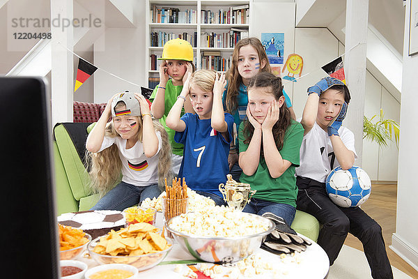 Kindergruppe bei der Fußball-WM mit Tisch voller Süßigkeiten und Snacks