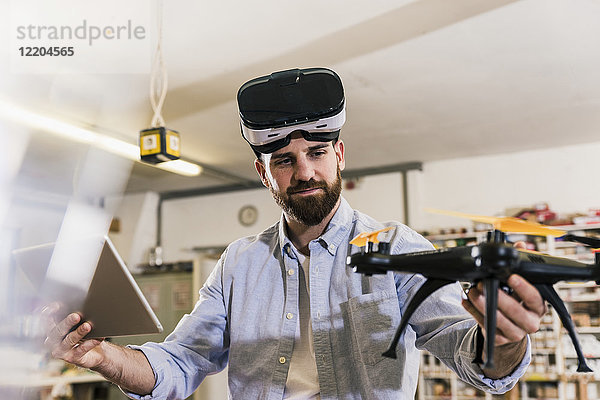 Mann mit VR-Brille mit Drohne und Tablette