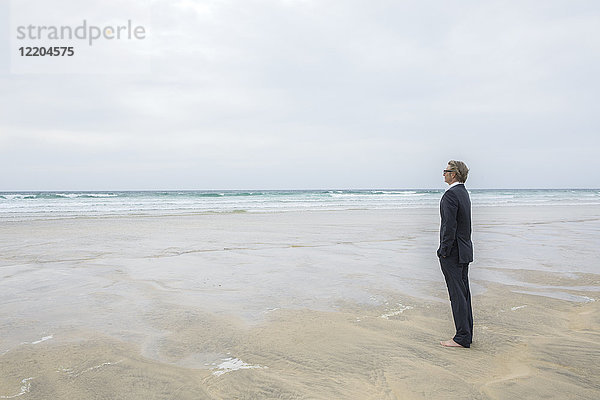 UK  Cornwall  Hayle  Geschäftsmann am Strand stehend mit Blick auf den Strand