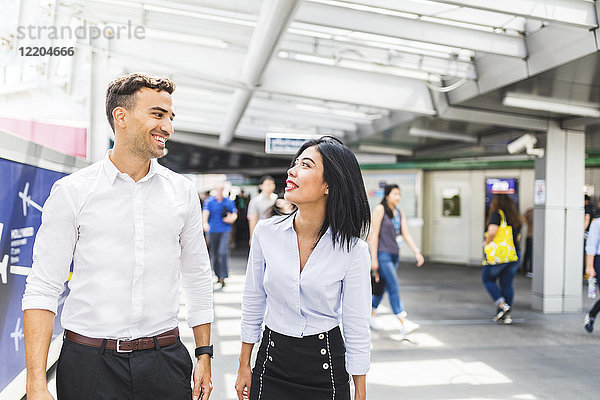 Thailand  Bangkok  lächelnder Geschäftsmann und Geschäftsfrau unterwegs in der Stadt