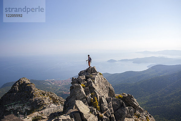 Wanderer bewundert das Meer vom Gipfel des Monte Capanne  Insel Elba  Provinz Livorno  Toskana  Italien  Europa