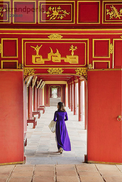 Eine Frau in einem traditionellen Ao Dai Kleid in der Verbotenen Purpurnen Stadt Hue  UNESCO Weltkulturerbe  Thua Thien Hue  Vietnam  Indochina  Südostasien  Asien