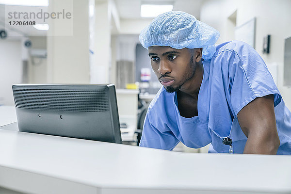 Schwarzer Arzt benutzt Computer im Krankenhaus