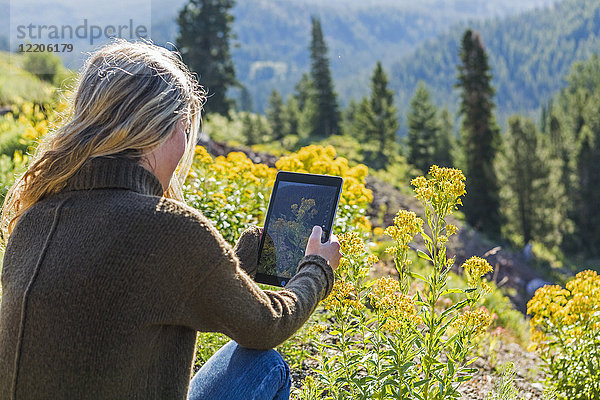 Kaukasisches Mädchen fotografiert Landschaft mit digitalem Tablet