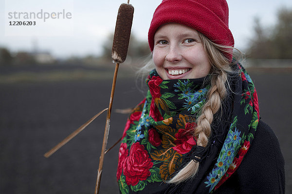 Porträt einer lächelnden kaukasischen Frau mit Schal und Strumpfmütze