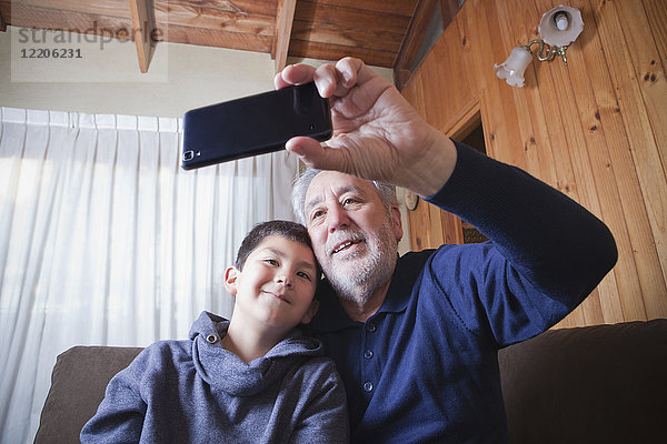 Hispanischer Großvater und Enkel posieren für ein Selfie mit dem Handy