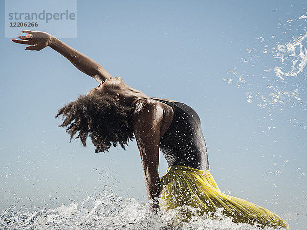 Schwarze Frau tanzt im Wasser