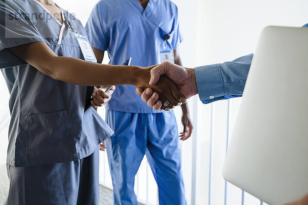 Arzt und Krankenschwester schütteln sich die Hände