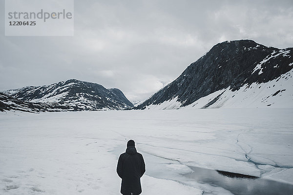 Kaukasischer Mann in einer Berglandschaft im Winter