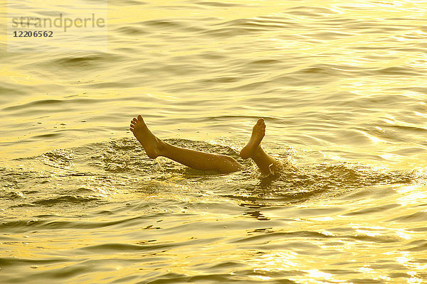 Füße eines kaukasischen Jungen  der aus dem Wasser ragt