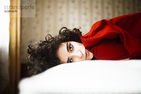 Porträt einer ernsten kaukasischen Frau auf dem Bett