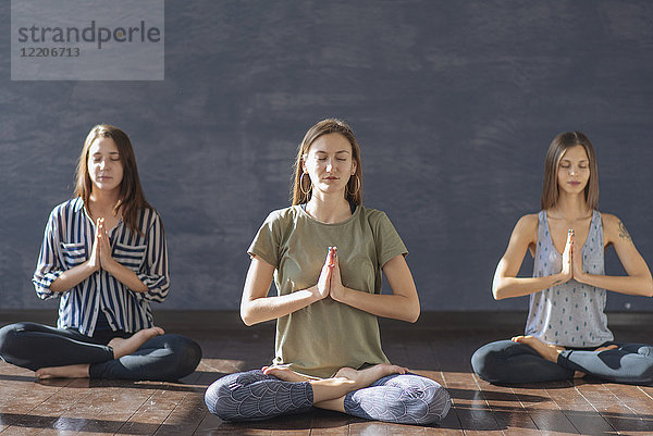 Kaukasische Frauen meditieren im Yoga-Kurs