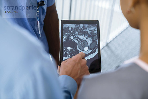 Nahaufnahme von Arzt und Krankenschwestern  die ein Bild auf einem digitalen Tablet betrachten
