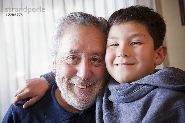Hispanischer Großvater und Enkel umarmen sich
