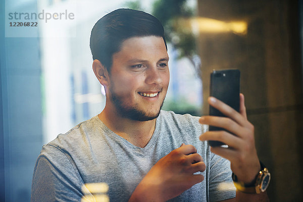 Smiling Caucasian man posing for cell phone selfie