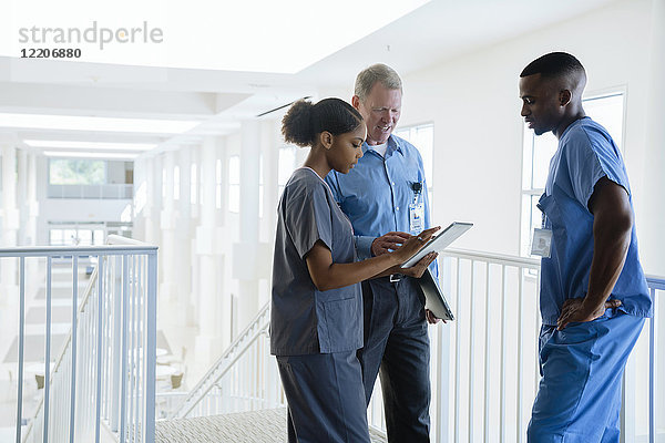 Doctor and nurses using digital tablet near staircase